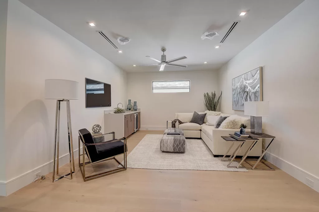 Modern and minimalist living room with neutral tones, featuring a sofa, chairs, coffee table, and wall art.