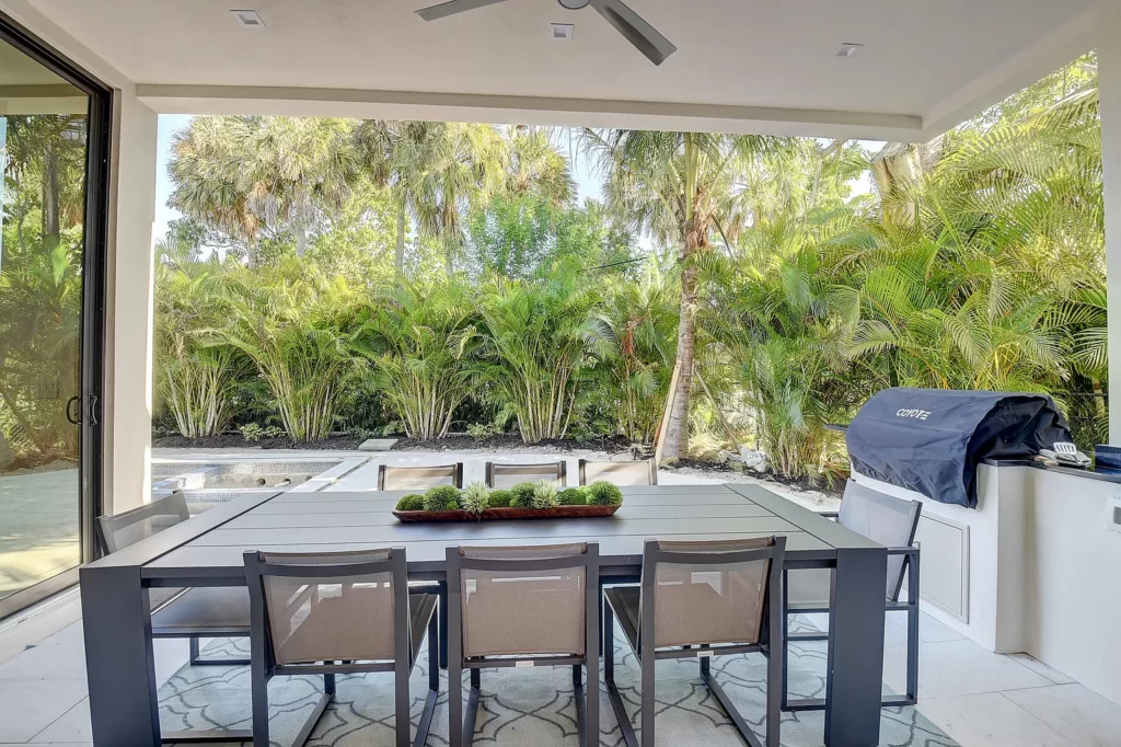 Modern outdoor dining area with a view of lush greenery.