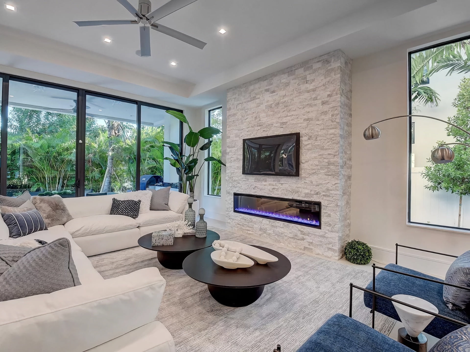 Modern and bright living room with wall mounted television and fireplace.